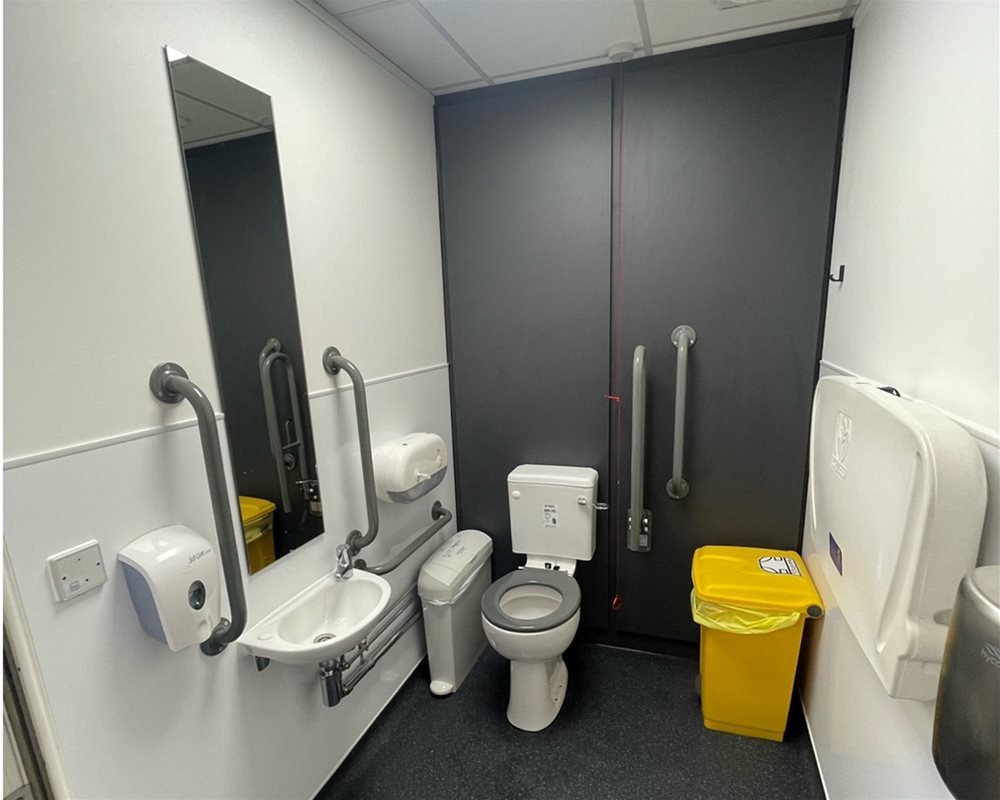 Dark grey duct panels and flashgaps, used for DOC M room with white ceramic close coupled WC with grey seat and grey grab rails.